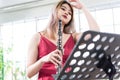 Beautiful young woman in a red dress playing the clarinet .,Classical musician oboe playing Royalty Free Stock Photo