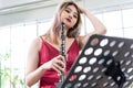 Beautiful young woman in a red dress playing the clarinet .,Classical musician oboe playing Royalty Free Stock Photo