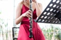 Beautiful young woman in a red dress playing the clarinet .,Classical musician oboe playing Royalty Free Stock Photo