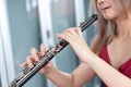 Beautiful young woman in a red dress playing the clarinet .,Classical musician oboe playing Royalty Free Stock Photo