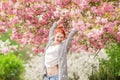 Beautiful young woman with red hair having fun standing in cherry blossom tree Royalty Free Stock Photo