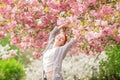 Beautiful young woman with red hair having fun standing in cherry blossom tree Royalty Free Stock Photo