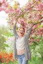 Beautiful young woman with red hair having fun standing in cherry blossom tree Royalty Free Stock Photo