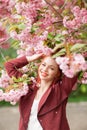 Beautiful young woman with red hair having fun standing in cherry blossom tree Royalty Free Stock Photo