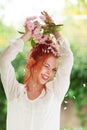 Beautiful young woman with red hair having fun standing in the garden with cherry blossom branch Royalty Free Stock Photo