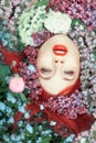 Beautiful young woman with red hair lying in colorful flowers, close up face Royalty Free Stock Photo