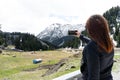 beautiful young woman with red hair photographer takes a picture of a mountain landscape on the phone while hiking Royalty Free Stock Photo