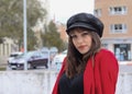 Beautiful young woman with red jacket and leather cap Royalty Free Stock Photo