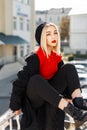 Beautiful young woman with red lips in a trendy black autumn