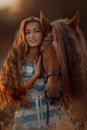 Beautiful  young woman with red tinker horse in rue field Royalty Free Stock Photo