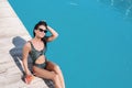 Beautiful young woman with refreshing cocktail near swimming pool on sunny day Royalty Free Stock Photo