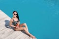 Beautiful young woman with refreshing cocktail near swimming pool on sunny day Royalty Free Stock Photo