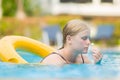 Beautiful young woman relax on life ring in pool with Frangipani flower Royalty Free Stock Photo