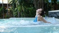 Beautiful young woman relaxes in a hydromassage jacuzzi, in swimming pool. Concept: spa procedures, body massages, spa Royalty Free Stock Photo