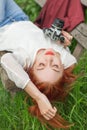 Beautiful young woman relaxing with camera in her hand on garden bench Royalty Free Stock Photo