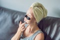 Beautiful young woman relaxing with face mask at home. Happy joy Royalty Free Stock Photo