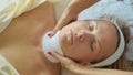 Beautiful young woman relaxing with face massage at luxury spa salon, close-up. Royalty Free Stock Photo