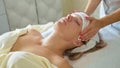 Beautiful young woman relaxing with face massage at luxury spa salon, close-up. Royalty Free Stock Photo