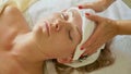 Beautiful young woman relaxing with face massage at luxury spa salon, close-up. Royalty Free Stock Photo