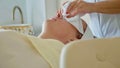 Beautiful young woman relaxing with face massage at luxury spa salon, close-up. Royalty Free Stock Photo