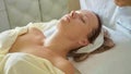 Beautiful young woman relaxing with face massage at luxury spa salon, close-up. Royalty Free Stock Photo