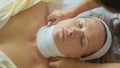 Beautiful young woman relaxing with face massage at luxury spa salon, close-up. Royalty Free Stock Photo