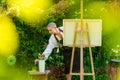 Beautiful young woman relaxing while painting an art canvas outdoors in her garden. Cancer survivor, mindfulness, art therapy. Royalty Free Stock Photo