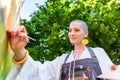 Beautiful young woman relaxing while painting an art canvas outdoors in her garden. Cancer survivor, mindfulness, art therapy. Royalty Free Stock Photo