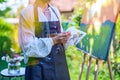 Beautiful young woman relaxing while painting an art canvas outdoors in her garden. Mindfulness, art therapy.