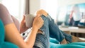 Young woman relaxing on the sofa at home, watching tv and enjoying coffee Royalty Free Stock Photo