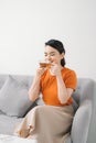 Beautiful young woman relaxing on sofa with laptop and a cup of tea in home Royalty Free Stock Photo