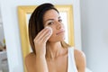 Beautiful young woman removing make up in front of mirror in the bathroom Royalty Free Stock Photo