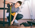 Beautiful young woman repairman measures the length of the shelf with a tape measure while making repairs in the house Royalty Free Stock Photo