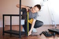 Beautiful young woman repairman measures the length of the shelf with a tape measure while making repairs in the house