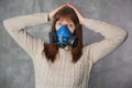 Beautiful young woman in respirator stand on grey background