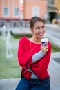 Beautiful young woman resting outside at a well while drinking c