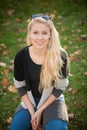 BEAUTIFUL YOUNG WOMAN RESTS IN PARK ON A WARM AUTUMN DAY