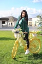 Beautiful young woman riding a yellow bike Royalty Free Stock Photo