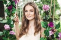 Beautiful Young Woman with Rose Flowers Outdoors