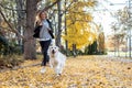 Beautiful young woman running with her lovely golden retriever dog in the park in autumn Royalty Free Stock Photo