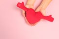 Beautiful young woman`s hands holding  plush heart on pastel pink background Royalty Free Stock Photo