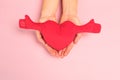 Beautiful young woman`s hands holding  plush heart on pastel pink background Royalty Free Stock Photo