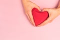 Beautiful young woman`s hands holding  plush heart on pastel pink background Royalty Free Stock Photo