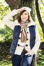 Beautiful young woman saluting under the beech tree in autumn na Royalty Free Stock Photo