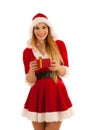 Beautiful young woman in santa claus dress hods a present isolated over white background