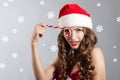 Beautiful young woman in a Santa Claus hat. Christmas portrait of a girl with a licorice candy Royalty Free Stock Photo