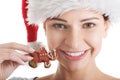 Beautiful young woman in santa hat eating gingerbread cookie. Royalty Free Stock Photo