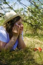 Beautiful young woman in a shag, lying on the field, green grass, apples and flowers. Outdoors enjoy nature. Healthy smiling girl Royalty Free Stock Photo