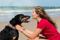 beautiful young woman sharing a tender moment with her dog on the beach Royalty Free Stock Photo