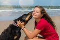 beautiful young woman sharing a tender moment with her dog on the beach Royalty Free Stock Photo